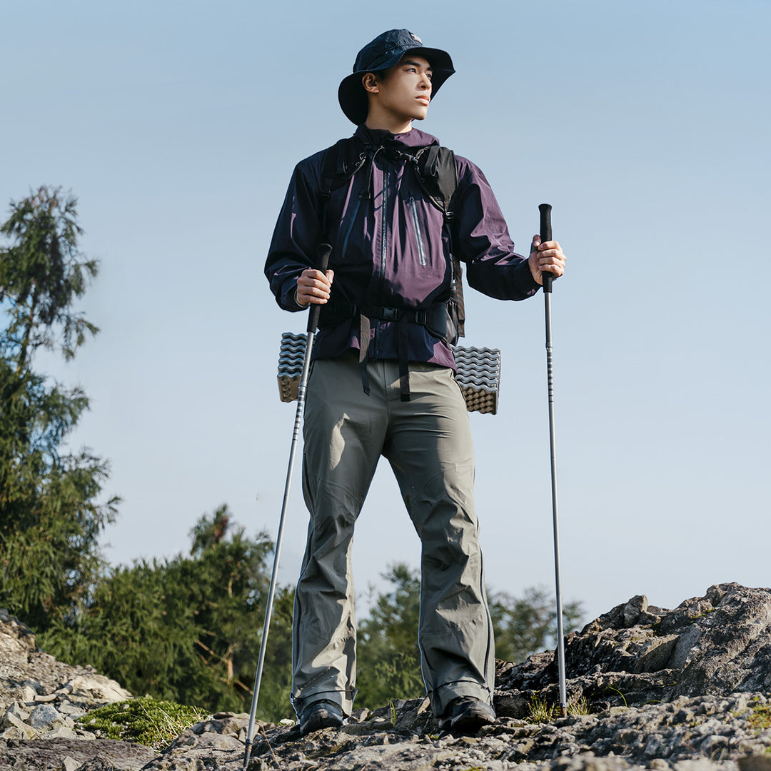 turysta z składanymi kijami trekkingowymi maszerujący po górskiej ścieżce w Alpach