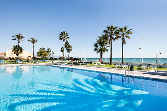 plaża przed hotelem w Maladze błękitne morze i złoty piasek plaży obok hotelu z leżakami