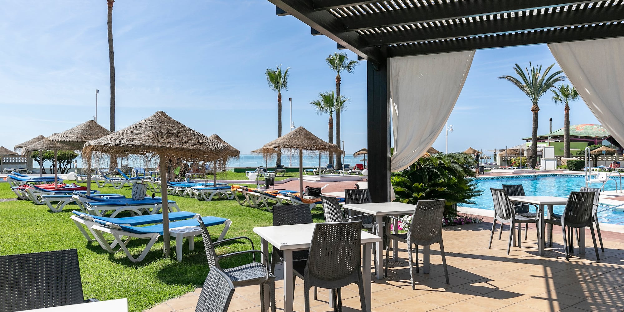 spacer nad morzem w Maladze ścieżka spacerowa wzdłuż wybrzeża z palmami i budynkami hotelowymi w tle