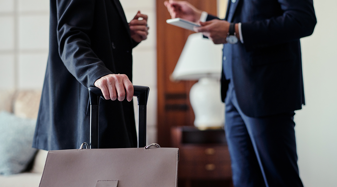 Rozzłoszczony turysta gestykuluje przy recepcji hotelowej skarżąc się na nocny hałas