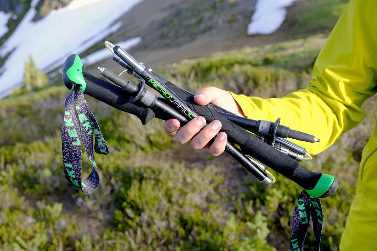 grupa turystów z identycznymi składanymi kijami na szczycie góry o zachodzie słońca